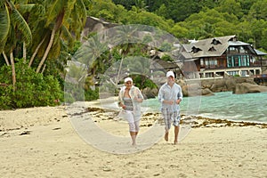 Elderly couple running on beach