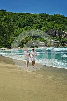 Elderly couple running on beach