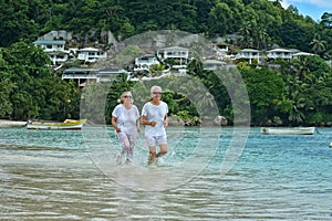 Elderly couple running on beach