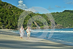 Elderly couple running on beach