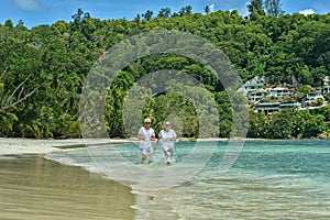 Elderly couple running on beach