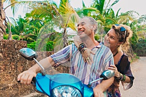 Elderly couple on scooter travel in summer dating relationship concept