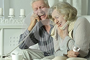 An elderly couple is sick and uses an inhaler