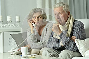 An elderly couple is sick and uses an inhaler