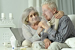 An elderly couple is sick and uses an inhaler