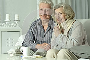 An elderly couple is sick and uses an inhaler