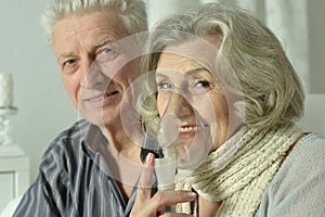 An elderly couple is sick and uses an inhaler