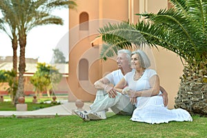 Elderly couple sitting on grass
