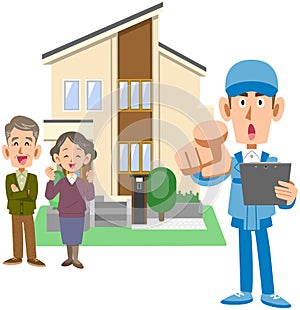 An elderly couple standing in front of a house and a man in work clothes holding a document in one hand and pointing it out