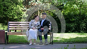 An elderly couple strolling peacefully in the park. A man and woman enjoying a leisurely walk amidst nature.