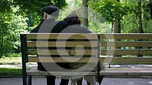 An elderly couple strolling peacefully in the park. A man and woman enjoying a leisurely walk amidst nature.