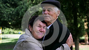 An elderly couple strolling peacefully in the park. A man and woman enjoying a leisurely walk amidst nature.