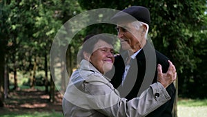 An elderly couple strolling peacefully in the park. A man and woman enjoying a leisurely walk amidst nature.