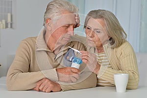 elderly couple at the table treating an illness at home