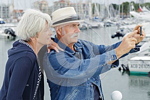 elderly couple taking selfie harbourside