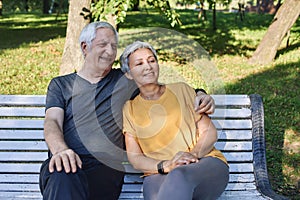 Elderly couple talking resting sit on bench in park