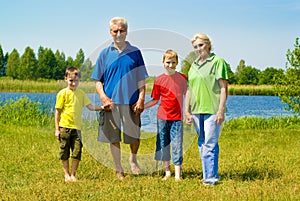 Elderly couple with their grandchildren playing so