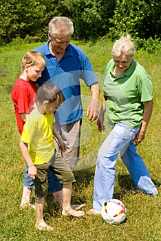 Elderly couple with their grandchildren playing