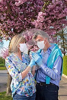 Elderly couple wearing surgical masks and gloves