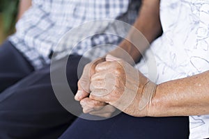 Elderly couples holding older hands and sitting together. Concept of take care together
