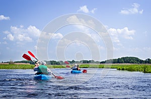 Elderly couples kayaking on river