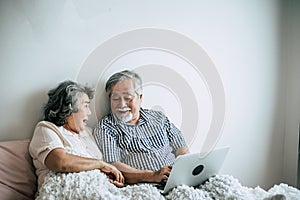 Elderly couples using laptop in bedroom