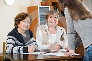 Elderly cute positive women making will at public notary office