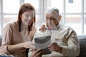 Elderly dad sharing success in working on pad with daughter