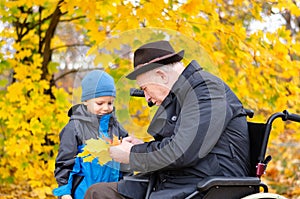 Elderly disabled man playing with his grandson outdoors