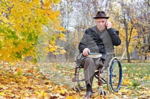 Elderly disabled man in a wheelchair in a park