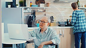 Elderly disabled person working on laptop