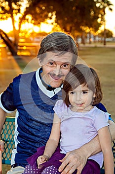 Elderly Downs Syndrome Man Holds His Great Niece in His Lap With photo