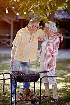 Elderly family  preparing barbecue in garden together