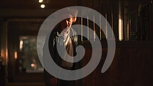 Elderly farmer standing near stall in sunbeam