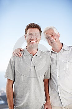 Elderly father, man and hug for portrait with smile, outdoor and bonding on vacation with summer sky. Senior dad, son