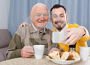 Elderly father and son doing selfie