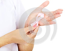 Elderly female doctor or nurse holds pink breast cancer awareness ribbon