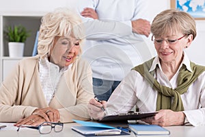 Elderly female friends studying together