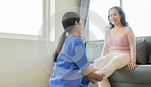 Elderly female patient with Asian female physical therapist holding her arm for physical therapy Rehabilitate weak muscles.