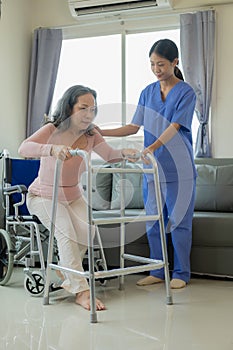 Elderly female patient with Asian female physical therapist holding her arm for physical therapy Rehabilitate weak muscles. photo