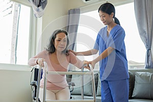 Elderly female patient with Asian female physical therapist holding her arm for physical therapy Rehabilitate weak muscles.