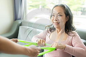 Elderly female patient with Asian female physical therapist holding her arm for physical therapy Rehabilitate weak muscles. photo