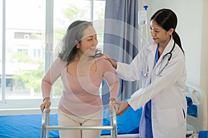 Elderly female patient with Asian female physical therapist holding her arm for physical therapy Rehabilitate weak muscles. photo