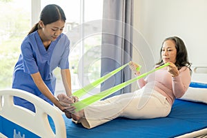 Elderly female patient with Asian female physical therapist holding her arm for physical therapy Rehabilitate weak muscles. photo