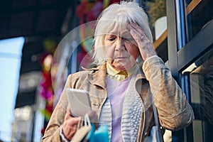 Elderly female reading something in the screen mobile phone