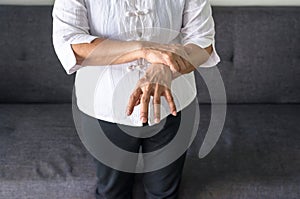 Elderly female suffering with parkinson`s disease symptoms photo