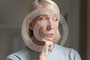 Elderly female thinking about life having melancholic mood closeup face