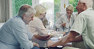 Elderly, friend group and playing cards in home or drinking wine for reunion party, weekend or celebration. Man, woman