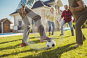 Elderly friends having fun playing football on a sunny summer day