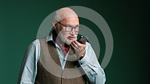 Elderly gentleman engaged in serious speakerphone conversation